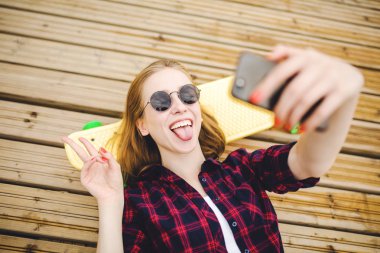 Hipster kıyafeti ile yalan ahşap iskele üzerinde selfie yapma genç şık kentsel kız