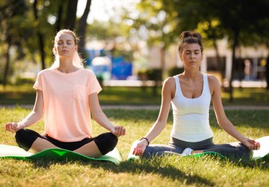 Kadınlar yoga açık havada güneş doğarken yapıyor. Sabah meditasyon