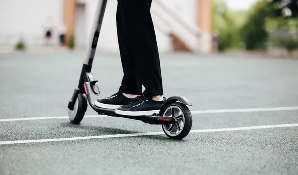 Beine eines Mannes in stylischem Outfit stehen auf Elektroroller auf der Straße — Stockfoto