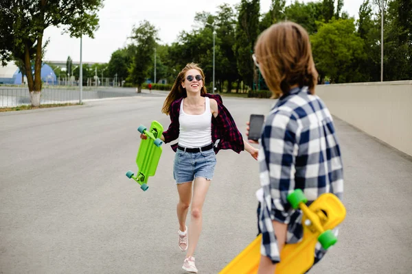 Dos alegres chicas felices en traje hipster divirtiéndose en la calle durante las vacaciones de verano —  Fotos de Stock