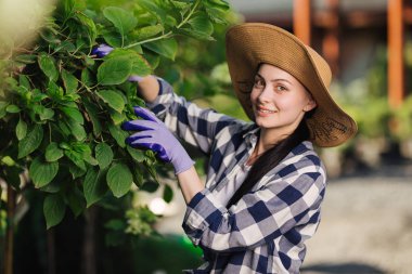 Kareli gömlek ve hasır şapka dışında yaz gününde bahçe güzel genç kadın