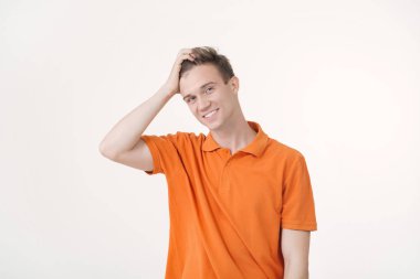 Dost görünümlü Avrupa adam ayakta beyaz arka plan üzerinde gülümseyen turuncu gömlek giymiş