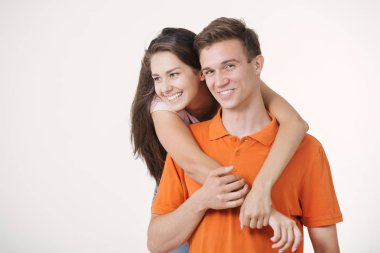 Mutlu güzel çifte sarılma ve beyaz arka plan üzerinde kameraya bakarak gülen