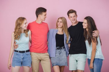 Mutlu gülümseyen genç grup arkadaşıyla birlikte konuşmak ve gülüyor. En iyi dostlar