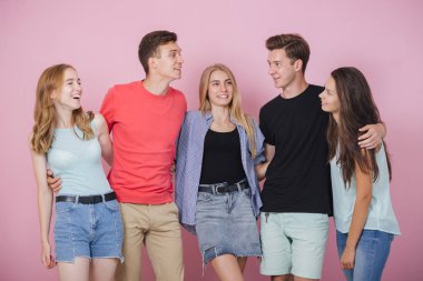 Mutlu gülümseyen genç grup arkadaşıyla birlikte konuşmak ve gülüyor. En iyi dostlar