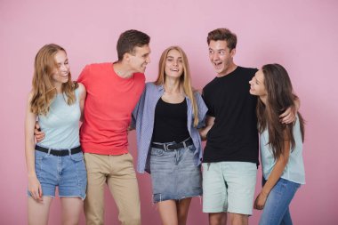 Mutlu gülümseyen genç grup arkadaşıyla birlikte konuşmak ve gülüyor. En iyi dostlar.