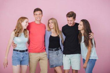 Mutlu gülümseyen genç grup arkadaşıyla birlikte konuşmak ve gülüyor. En iyi dostlar