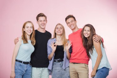 Mutlu gülümseyen genç grup arkadaşıyla birlikte konuşmak ve gülüyor. En iyi dostlar