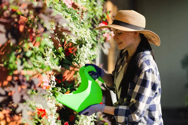 Hermosa mujer jardinero regando plantas en el jardín en el día caluroso de verano. Concepto de jardinería — Foto de Stock
