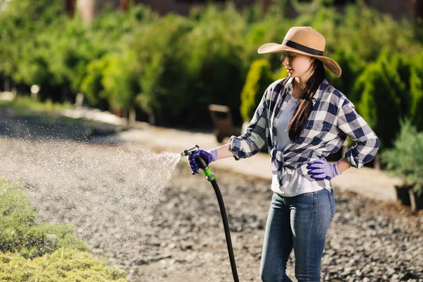 Vrouw van de mooie jonge tuinman drenken de tuin in warme zomerdag — Stockfoto
