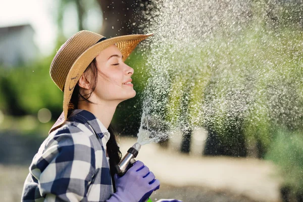 Mooie jonge tuinman vrouw plezier terwijl het Bewateren van de tuin in warme zomerdag — Stockfoto