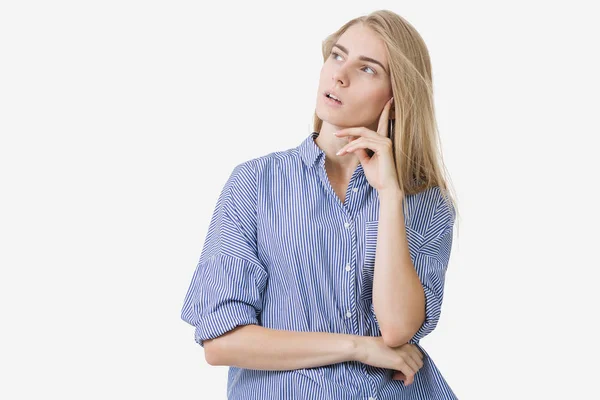 Porträtt av ung blond Europeiska tjej klädd i blå randig skjorta tänka på något över vit bakgrund — Stockfoto
