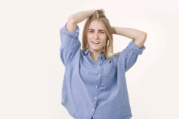 Portret van jonge vrolijke blonde vrouw draagt blauwe shirt tegen witte achtergrond — Stockfoto