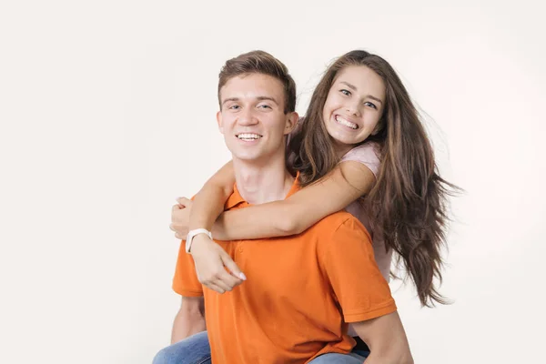 Feliz lindo casal abraçando e sorrindo olhando para a câmera no fundo branco — Fotografia de Stock