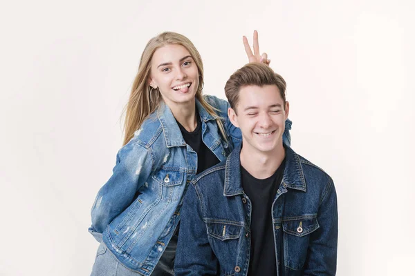 Woman pranking her boyfriend with bunny ears. Studio shot over white background — Stock Photo, Image