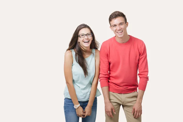 Χαρούμενος νεαρός υπέροχο ζευγάρι στέκεται μαζί και γελώντας. Στούντιο πυροβόλησε πάνω από το λευκό φόντο. Έννοια φιλία, αγάπη και σχέσεις — Φωτογραφία Αρχείου