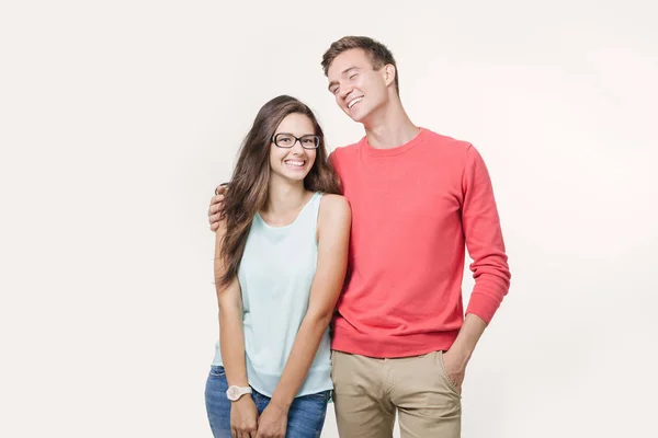 Happy young lovely couple standing together and laughing. Studio shot over white background. Friendship, love and relationships concept — Stock Photo, Image