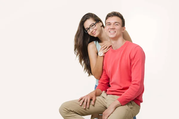 Feliz lindo casal abraçando e sorrindo olhando para a câmera no fundo branco — Fotografia de Stock