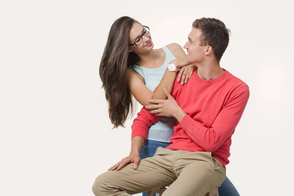 Feliz pareja encantadora abrazándose y sonriendo mirándose el uno al otro sobre fondo blanco —  Fotos de Stock