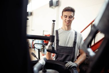 Bir araba servis ve bakım onun iş adlı bir genç gülümseyen automechanic olduğunu