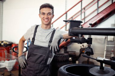 Genç ve kaliteli automechanic kısa bir mola sırasında işteyken gülümsüyor