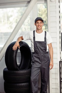 Genç tamirci birkaç lastikleri duruyor