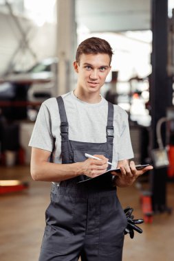 Yakışıklı bir automechanic bir araba servisi günün sonunda duruyor