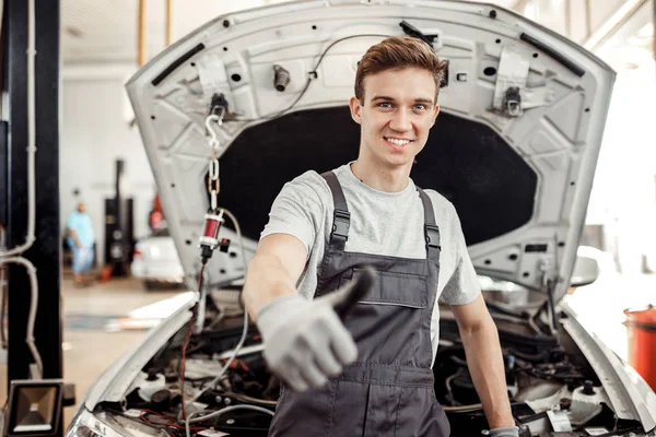 Un beau jeune homme est à son travail : service de réparation automobile — Photo