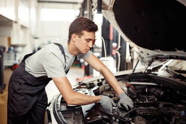 Autoservice und -wartung: Automechaniker repariert ein Fahrzeug — Stockfoto