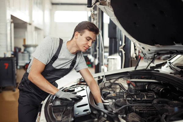 Bei der Arbeit: Automechaniker sucht Fehler im Motor — Stockfoto
