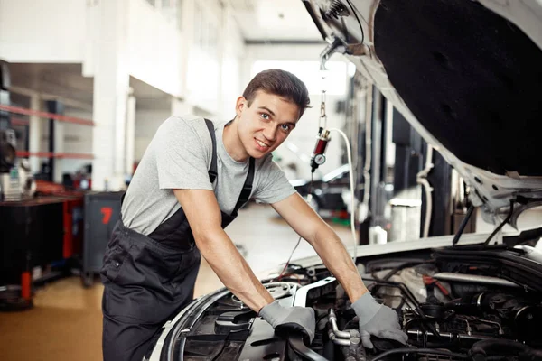 Ein attraktiver Mechaniker repariert ein Fahrzeug — Stockfoto