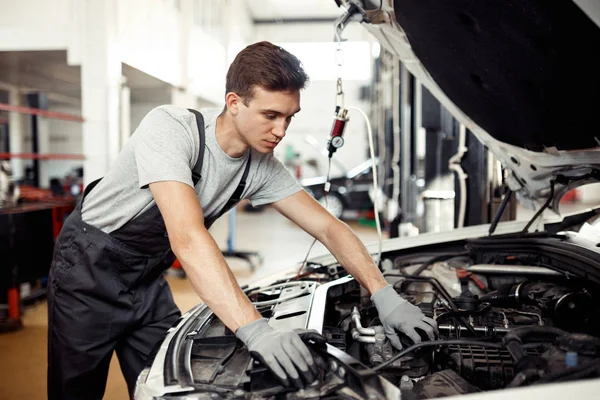 Ein Mann sucht Käfer an einem Automotor — Stockfoto