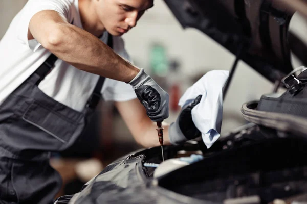 Un mecánico calificado está trabajando en errores en un coche — Foto de Stock