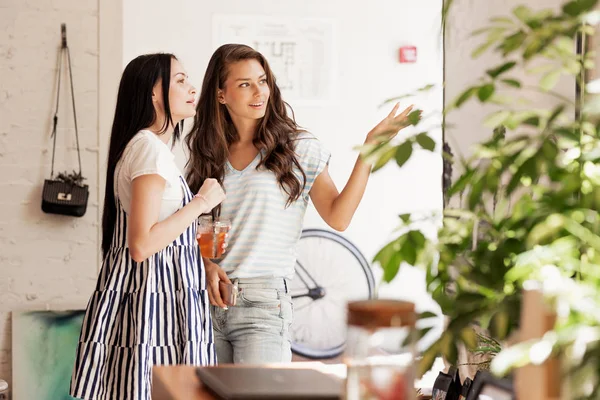 Duas meninas magras jovens com cabelos longos e escuros conversam umas com as outras em um aconchegante café . — Fotografia de Stock