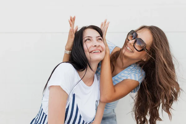 Twee jeugdige dark-haired meisjes, het dragen van casual outfit, mooie knuffel elkaar en kijken naar de camera. — Stockfoto