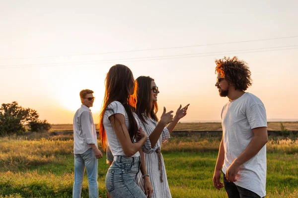 Gruppe junger stylischer Typen, die an einem sonnigen Tag auf der Straße reden — Stockfoto