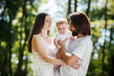 Yakışıklı bir adam ve genç güzel eşi onların küçük kızı ormanın içinde temiz hava silah tutun.