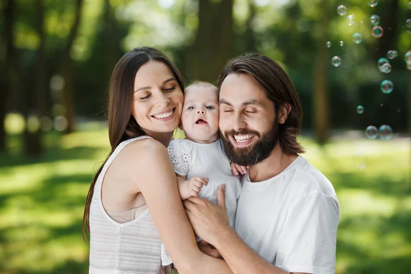 Glorieux parents et leur petite fille vêtus de beaux vêtements blancs — Photo