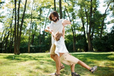 Güneşli bir gün genç esmer Baba ve küçük oğlu eğleniyor ve açık oynayan beyaz t shirt.
