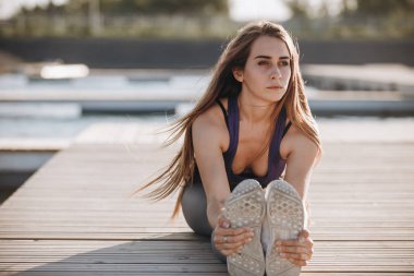Bir spor top ve ahşap iskele üzerinde uzanan yapıyor tayt uzun kahverengi saçlı Genç ince kız