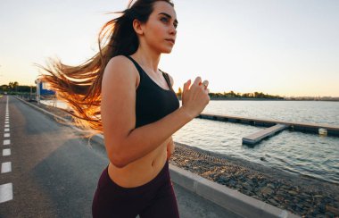 Sunset Bulvarında göl yolda bir spor top ve tayt uzun kahverengi saçlı güzel genç kız çalışır