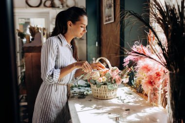 Çiçekçi bir çizgili elbise koleksiyonlarında bir buket pastel renklerin taze çiçekler sepetten çiçekçide giymiş