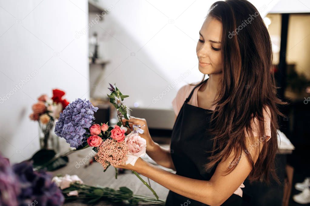 Florist collections a bouquet of fresh pink little roses, blue hydrangea and other flowers in the flower shop