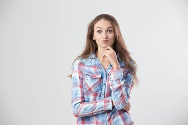 Sürpriz kız bir kareli gömlek giymiş stüdyoda beyaz arka plan üzerinde duruyor