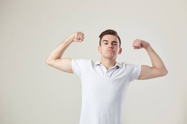 Adam beyaz bir t-shirt giymiş ve kot pantolon, güç ve enerji stüdyoda beyaz bir arka plan üzerinde tam