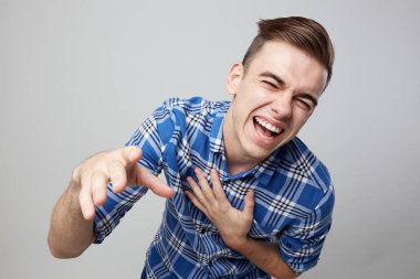 Neşeli adam giyinmiş bir ekose gömlek güler stüdyoda beyaz bir arka plan üzerinde