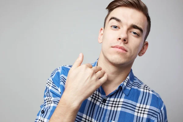 Self Confident cara vestida com uma camisa xadrez está em um fundo branco no estúdio — Fotografia de Stock