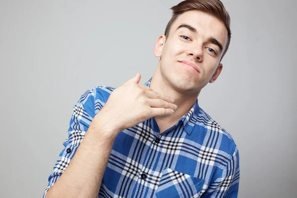 Self Confident cara vestida com uma camisa xadrez está em um fundo branco no estúdio — Fotografia de Stock