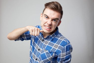 Bir ekose gömlek giymiş agresif stüdyoda beyaz bir arka planda biri