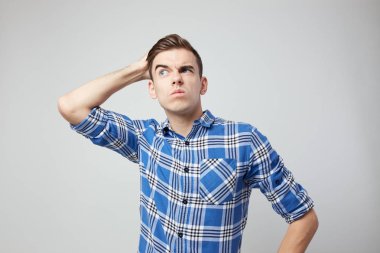 Bir ekose gömlek giymiş bir adam baş beyaz bir arka planda stüdyoda el koyar .